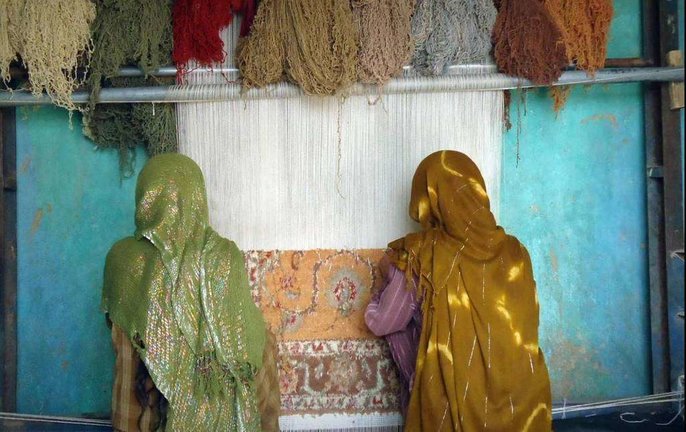 Mujeres afganas confeccionan una alfombra.