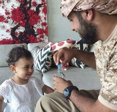 El jeque Theyab ofrece agua a una niña yemení.
