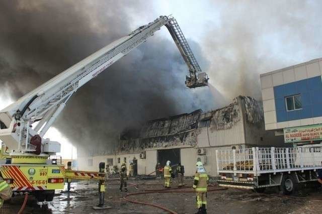Los bomberos trabajan en la extinción del fuego en un almacén de Ajman. (Defensa Civil de Ajmán)