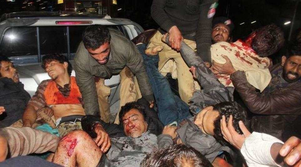Pakistaníes ayudan a los heridos por la explosión de la bomba.