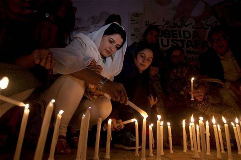 Mujeres pakistaníes encienden velas en homenaje a las víctimas del último ataque en un templo del país.