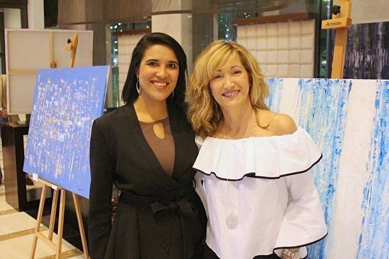 La pintora Paloma Redecilla -derecha- junto a Clara de Lama, relaciones públicas del hotel Southern Sun de Abu Dhabi, durante la inauguración de la muestra. (Cedida)