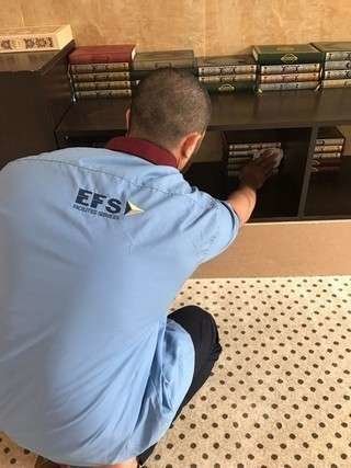 Uno de los sancionados con servicios comunitarios en Abu Dhabi, limpiando los libros de una biblioteca.