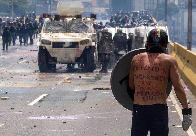 Un manifestante se enfrentan a la Guardia Nacional Bolivariana en Caracas ( Venezuela). EFE