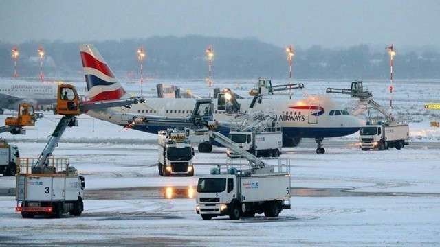 Empleados del aeropuerto de Dusseldorf quitan el hielo a un avión de British. (AFP) 