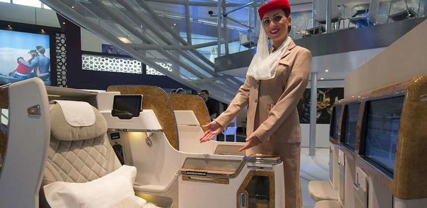 Una azafata muestra el nuevo asiento de la clase Business de Emirates.