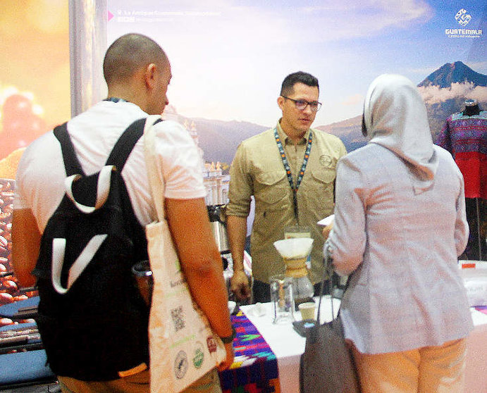 Raúl Rodas, campeón mundial de baristas, atiende a los visitantes en el stand de Guatemala en World of Coffee Dubai 2023. (EL CORREO)