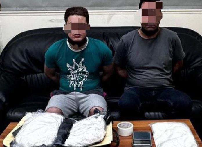 Los detenidos junto a la droga confiscada. (Policía de Abu Dhabi)