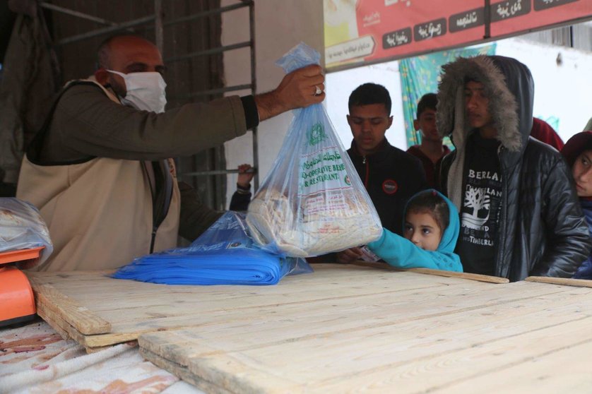 Voluntarios de Emiratos Árabes entregan ayuda alimentaria en Gaza. (WAM)
