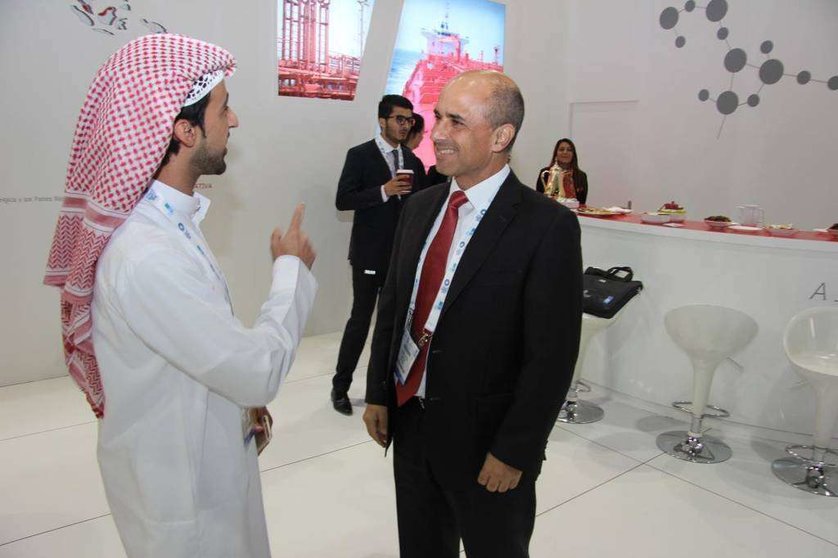  Juan Vera, director general de Operaciones de Cepsa, conversa con un emiratí en el expositor de la compañía en ADIPEC.