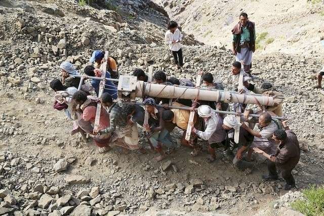 Combatientes progubernamentales en Yemen trasladan un cañón.