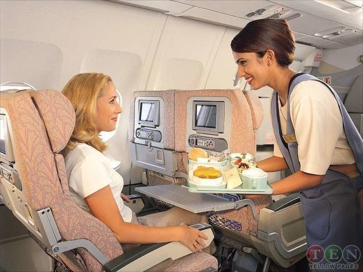 Servicio a una pasajera en un vuelo de Emirates Airline.