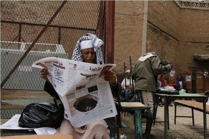 Un yemení lee el periódico en un mercado en Saná.