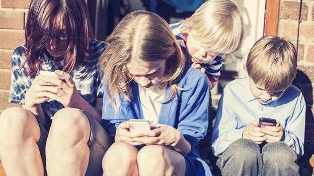 Una imagen de niños con teléfonos móvil suministrada de internet.