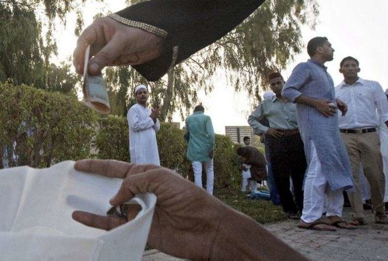 Un mendigo recibe una limosna en Dubai.