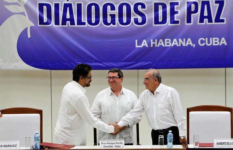 El jefe negociador de las FARC Luciano Marín, estrecha la mano al jefe negociador del Gobierno colombiano, Humberto de la Calle