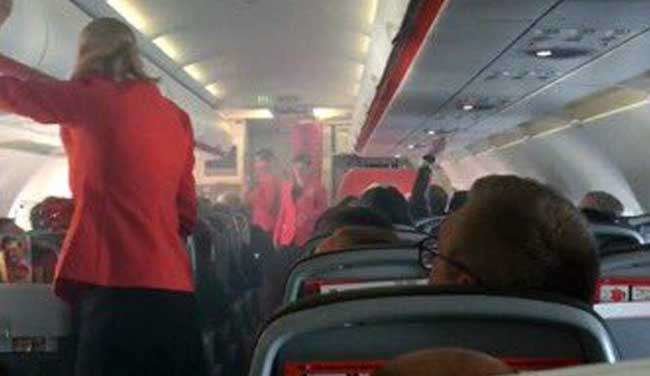 Las azafatas de Jetstar dan instrucciones a los pasajeros mientras la cabina se llena de humo. (Twitter)