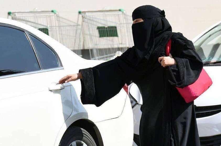 Una mujer saudí ante un vehículo estacionado.