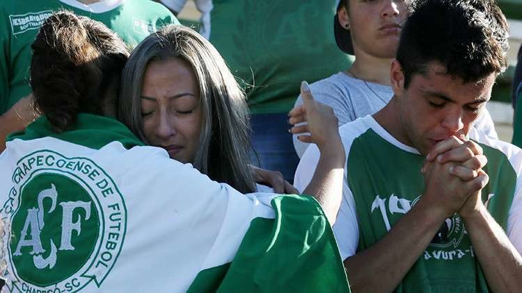 En la foto de Reuters jugadores del equipo brasileño se consuelan después de la tragedia.