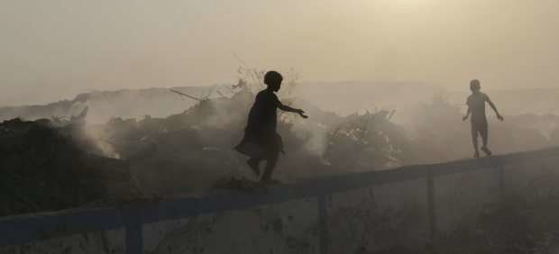 En la imagen de EFE unos niños jugando en un basurero en la India.