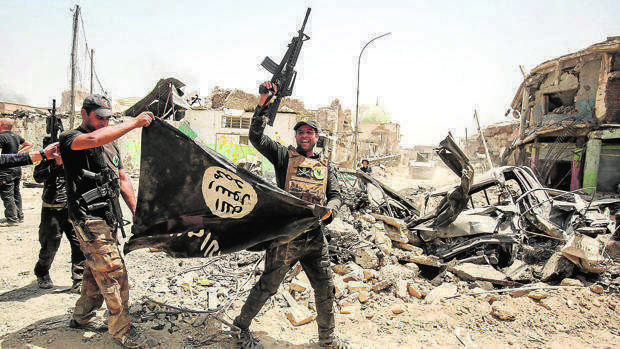 Soldados iraquíes bajan una bandera de Daesh en Mosul. (AFP)