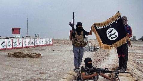 Un miembro del Daesh sostiene la bandera del Califato.
