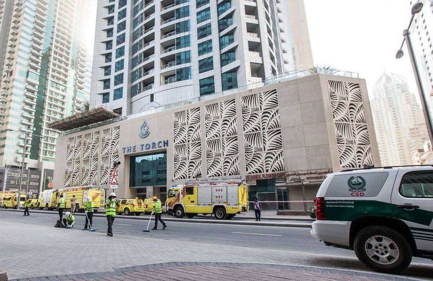 Operarios de limpieza trabajan para despejar los alrededores de la Torre Antorcha en Dubai Marina tras el incendio de este 4 de agosto. (Leslie Pableo,Khaleej Times)