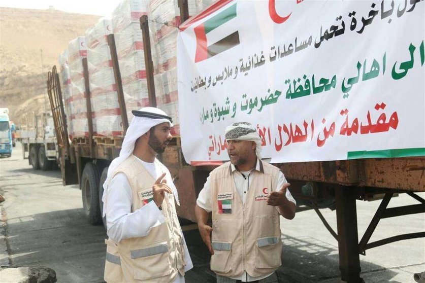 Responsables de la Media Luna Roja de Emiratos, durante la descarga de la ayuda alimentaria en el puerto de Al Mukalla. (WAM)