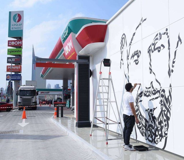 El artista Diaa Allem pintando el mural dedicado a Sheikh Zayed en una estación de servicio de ENOC. (WAM)