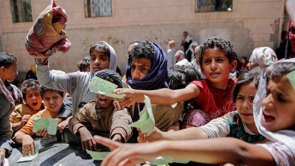 En la imagen de AP, niños yemeníes presentan documentos para acceder a la ayuda humanitaria.