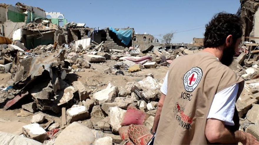Miembro de la Cruz Roja y escombros en Yemen. 