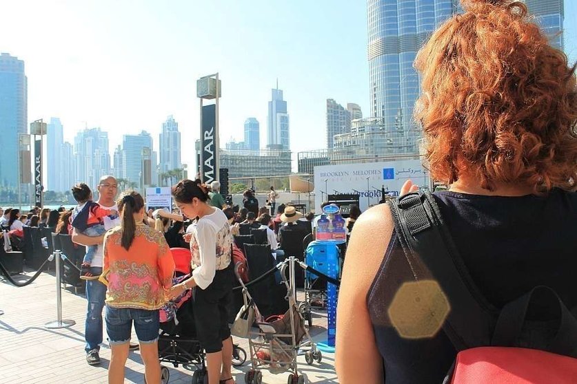 Turistas observan un espectáculo musical gratuito a los pies del Burj Khalifa. (Celia HK)