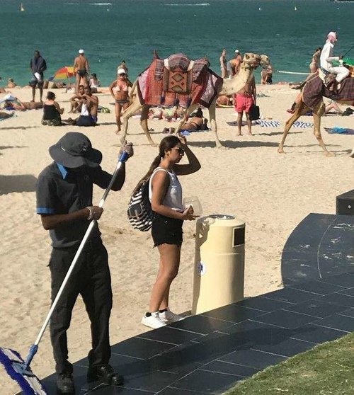 Un trabajador barre la playa de JBR en Dubai Marina. (EL CORREO)