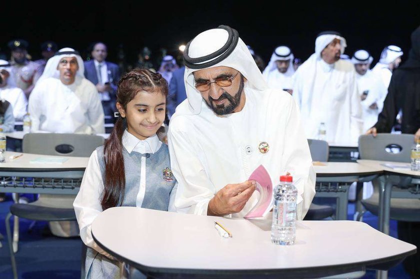 El jeque Mohamed bin Rashid Al Maktoum habla con una niña durante la presentación en Dubai de la plataforma 'Madrasa'. (WAM)