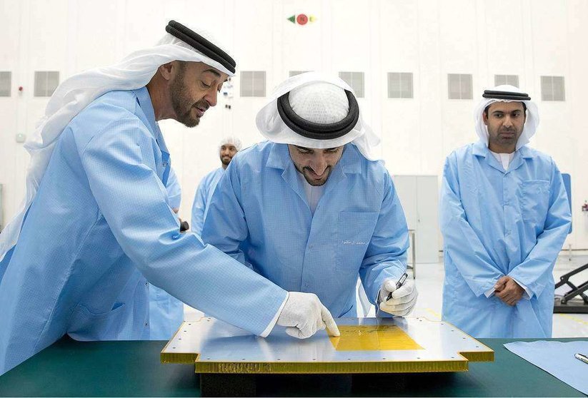 El jeque Hamdan bin Mohamed Al Maktoum, príncipe heredero de Dubai, firma la estructura del KhalifaSat durante una visita al Centro Espacial Mohammed bin Rashid, en presencia del jeque Mohamed bin Zayed Al Nahyan, príncipe heredero de Abu Dhabi. (WAM)