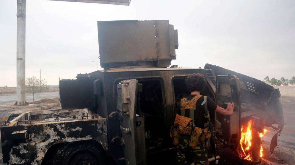 En la foto de AFP un rebelde hutí inspecciona un vehículo blindado quemado. 