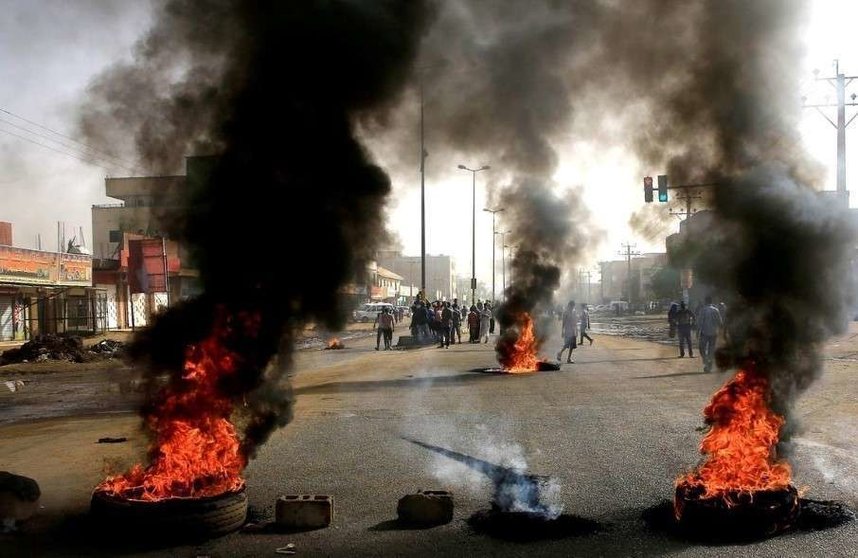 En la imagen de Reuters,  manifestantes sudaneses usan neumáticos quemados para erigir una barricada en una calle.