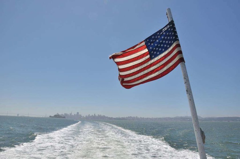 Barco con bandera estadounidense surca el mar. (pxhere.com)