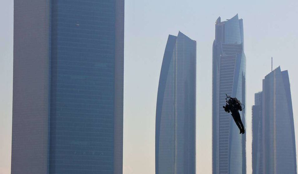 Un hombre volador pasea en Abu Dhabi ante el edificio de ADNOC, situado a la izquierda. (R. Pérez / EL CORREO)