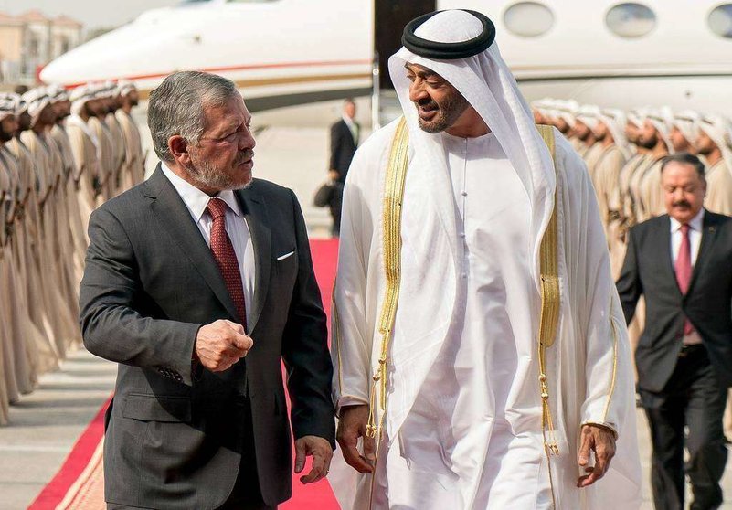 El príncipe heredero de Abu Dhabi -derecha- recibe al rey de Jordania en el aeropuerto de Al Bateen de la capital de Emiratos Árabes. (WAM)