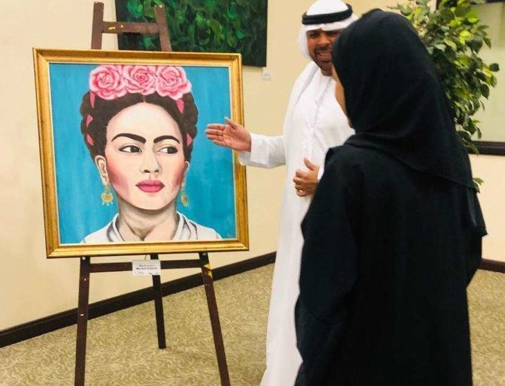 Dos emiratíes observan la pintura de la artista ecuatoriana Marisol Grijalva. (EL CORREO)