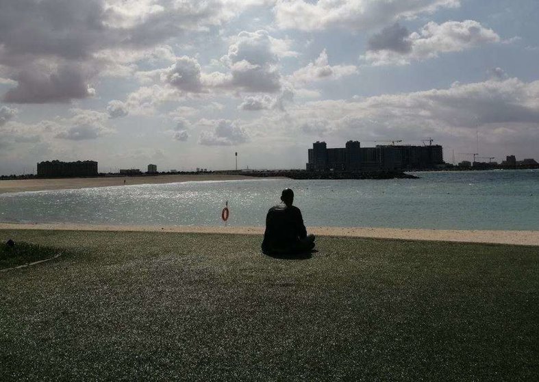 Un hombre descansa en una playa de Emiratos Árabes. (EL CORREO)