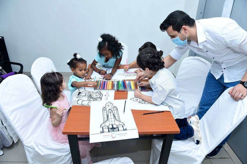 Niños colorean naves espaciales durante la jornada de puertas abiertas en la Ciudad Humanitaria. (WAM)