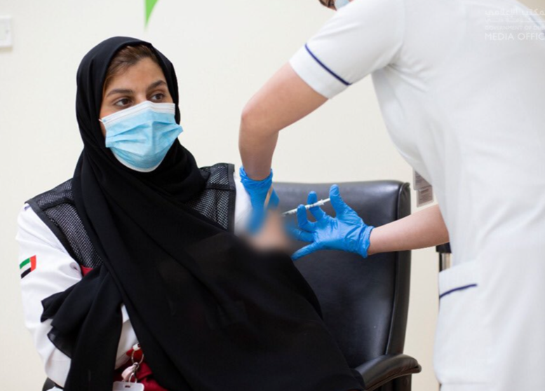Una emiratí recibe una dosis de la vacuna Covid. (WAM)