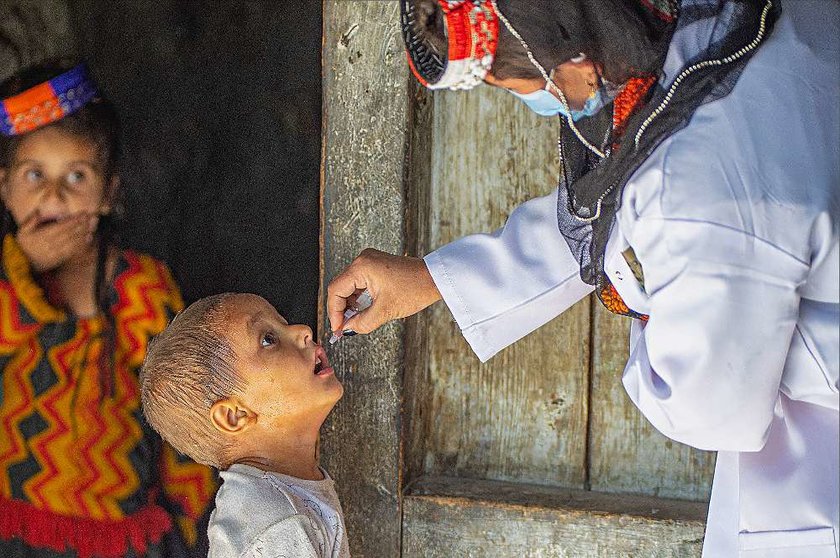 Un niño muy atento a lo que ocure recibe la dosis durante la campaña contra la polio impulsada por Emiratos Árabes en Pakistán. (WAM)